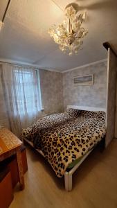 a bedroom with a leopard print bed with a chandelier at Guest House Krista in Jūrmala