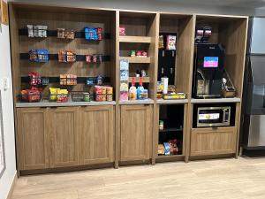 a pantry with wooden cabinets with food in it at Candlewood Suites Conway by IHG in Conway
