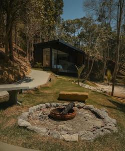 un bâtiment avec un foyer dans l'herbe dans l'établissement Chalé com banheira, piscina e cachoeira privativa, à Taubaté