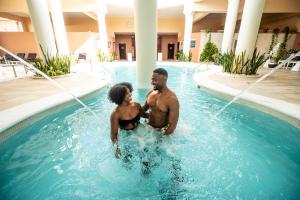 The Signature Level at Grand Palladium Lady Hamilton Resort & Spa- All Inclusive في لوتسيا: رجلين واقفين في مسبح