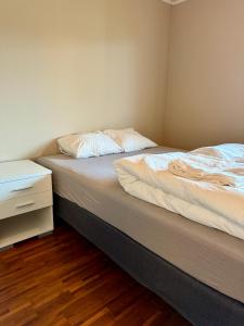 een slaapkamer met twee bedden en een nachtkastje bij Romslig leilighet nært sentrum in Tromsø