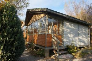 普拉伊德Natura Chalets的一栋带门廊和圣诞树的小房子