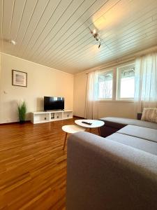 een woonkamer met een bank en een tv bij Romslig leilighet nært sentrum in Tromsø