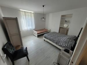 een slaapkamer met een bed, een dressoir en een stoel bij Appartement Jarny proche gare in Jarny