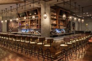 a bar with a row of chairs and lights at InterContinental Miami by IHG in Miami