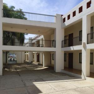 an empty building with two balconies and a parking lot at Hotel Azul Agave Oaxaca in Yelateni