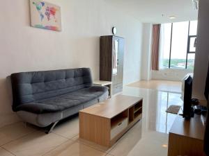 een woonkamer met een bank en een tafel bij SamStudio in Penampang