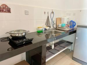 een aanrecht met een gootsteen en een pan op een fornuis bij SamStudio in Penampang