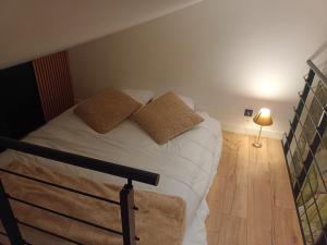 a bedroom with a bed with two pillows and a lamp at L'atelier Maillot in Évreux