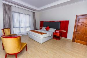 ein Hotelzimmer mit einem Bett und einer Holztür in der Unterkunft The Crest Apartment in Kigali