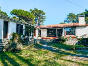 a house with a stone wall and a yard at Camarinhas House in Moledo