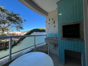 ein Balkon mit Kamin und Blick aufs Wasser in der Unterkunft Residencial Açores in Bombinhas