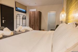 a bedroom with a large bed with white sheets at Trikala mall suites in Tríkala