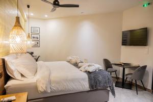 a bedroom with a bed and a desk and a television at Trikala mall suites in Tríkala +230 photos