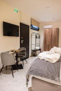 a bedroom with two beds and a table and chairs at Trikala mall suites in Tríkala