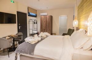 a bedroom with a white bed and a table and chairs at Trikala mall suites in Tríkala