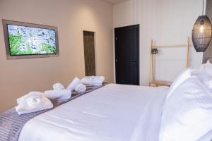 a bedroom with a white bed with towels on it at Trikala mall suites in Tríkala