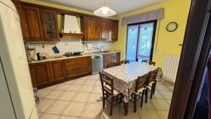 a kitchen with a table and chairs and a kitchen with yellow walls at Salseadine - Senigallia in Marzocca di Senigallia +7 photos