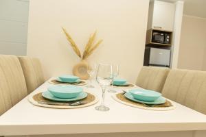 a dining room table with plates and wine glasses at Sirmium stay in Sremska Mitrovica