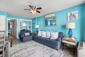 a living room with a couch and a ceiling fan at Palms Resort 905- Oceanfront in Myrtle Beach
