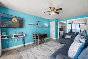 a blue living room with a couch and a table at Palms Resort 905- Oceanfront in Myrtle Beach