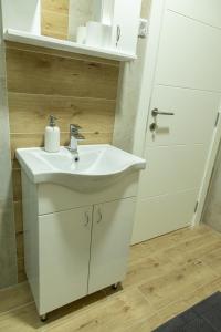 a bathroom with a white sink and a door at Sirmium stay in Sremska Mitrovica +17 photos