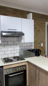 eine Küche mit Herd und Mikrowelle in der Unterkunft Unmatched Stays in Kempton Park