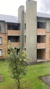 ein Gebäude mit einem Baum davor in der Unterkunft Unmatched Stays in Kempton Park