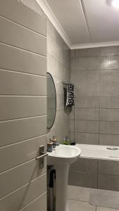 ein Badezimmer mit Waschbecken und Badewanne in der Unterkunft Unmatched Stays in Kempton Park + 11 Fotos