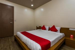 a bedroom with a large bed with red pillows at Hotel O Riddhi Siddhi in Indore