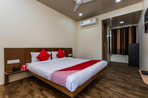 a bedroom with a large bed with red pillows at Hotel O Riddhi Siddhi in Indore
