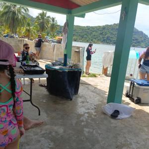 a group of people standing around a table near the water at Nilka sunset house in Colón +3 photos