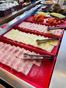 a display case with different types of meats and cheese at Hotel Ibis Tatui in Tatuí