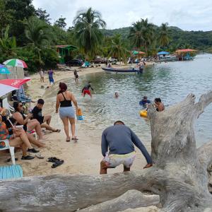 a group of people on a beach near the water at Nilka sunset house in Colón