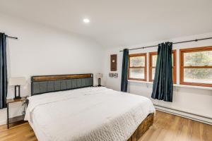 a bedroom with a large bed and two windows at Updated Getaway with Sauna and Yard in Bloomsbury! in Port Warren