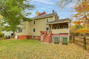 a yellow house with a fence and a yard at Updated Getaway with Sauna and Yard in Bloomsbury! in Port Warren