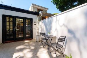 een terras met een tafel en stoelen en een gebouw bij Surry Hills Cottage in Sydney