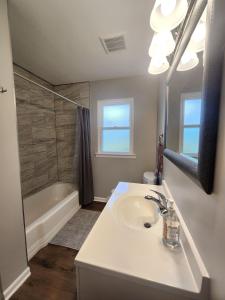 ein weißes Badezimmer mit Waschbecken und Dusche in der Unterkunft Naperville Gem in Naperville