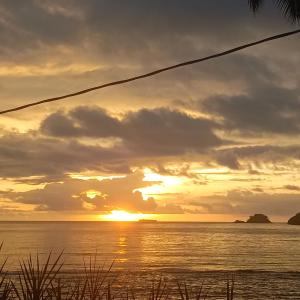 a sunset over the ocean with the sun setting at Nilka sunset house in Colón