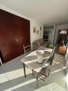 une table à manger et des chaises dans un salon dans l'établissement Amenidades y terraza vista mar, à Punta del Este