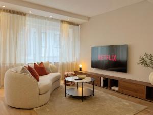 a living room with a couch and a tv at Seestadt Apartment I Sauna I Parkplatz I Zentral in Haltern