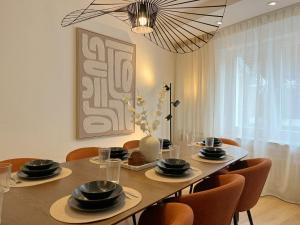 a dining room with a table with chairs and a chandelier at Seestadt Apartment I Sauna I Parkplatz I Zentral in Haltern