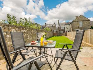 Throptonにある2 bed property in Rothbury Northumberland 89502の食べ物と椅子が置かれたテーブルのあるパティオ