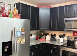 a kitchen with black cabinets and a stainless steel refrigerator at A Beary Good Getaway condo in Pigeon Forge