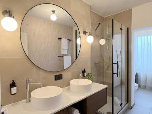 a bathroom with two sinks and a mirror at Seestadt Apartment I Sauna I Parkplatz I Zentral in Haltern