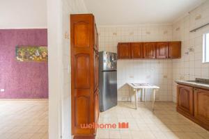 eine Küche mit Holzschränken und einem Edelstahlkühlschrank in der Unterkunft Casa no Centro de Peruibe a 750m da Praia in Peruíbe