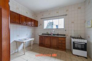 eine Küche mit einer Spüle, einem Herd und einem Fenster in der Unterkunft Casa no Centro de Peruibe a 750m da Praia in Peruíbe