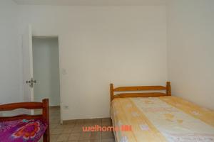 ein Schlafzimmer mit zwei Betten und einer Tür zu einem Zimmer in der Unterkunft Casa no Centro de Peruibe a 750m da Praia in Peruíbe + 13 Fotos