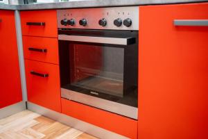 cocina con armarios rojos y horno en Kuća za odmor NADA, en Legrad