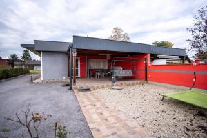 una casa con una pared roja y un patio en Kuća za odmor NADA, en Legrad